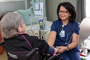 A nurse assisting an elderly lady